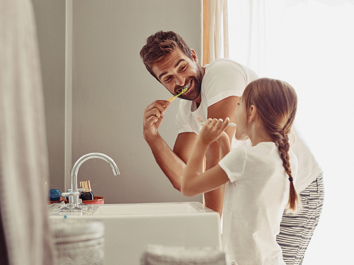 Father and daughter brushing teeth